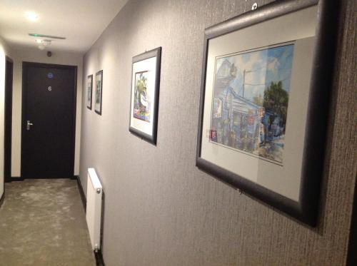a hallway with paintings on the walls of a building at Rooms @ Number Six in Oakham
