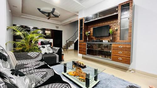 a living room with a couch and a tv at Premium 3 Bedroom Independent Villa in Indore