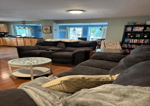 a living room with two couches and a table at Northern Maine Getaway in Fort Fairfield
