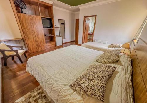 a hotel room with two beds and a leopard pillows at Pousada Victoria Villa By Nacional Inn - A 800 metros da Vila Capivari in Campos do Jordão