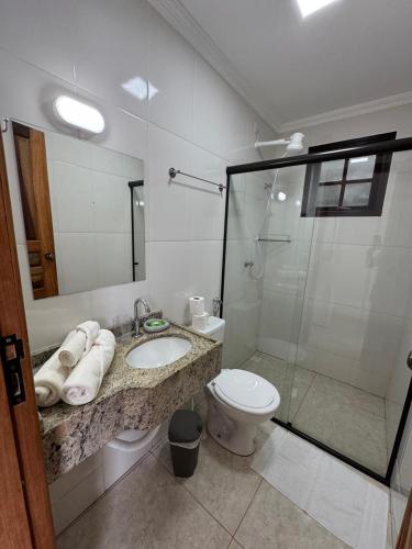 a bathroom with a toilet and a sink and a shower at Suítes Betel in Paraty
