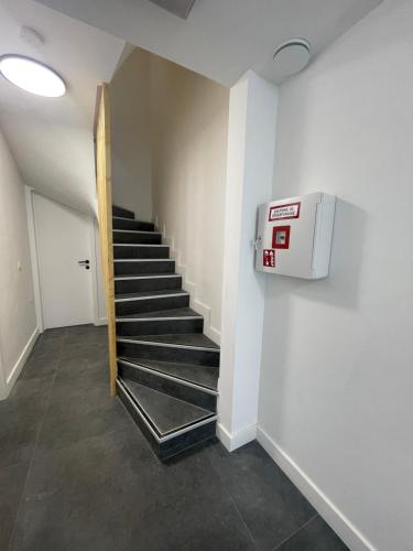 a hallway with a staircase with a dryer on the wall at Splendide appartement neuf à Zaventem airport in Zaventem