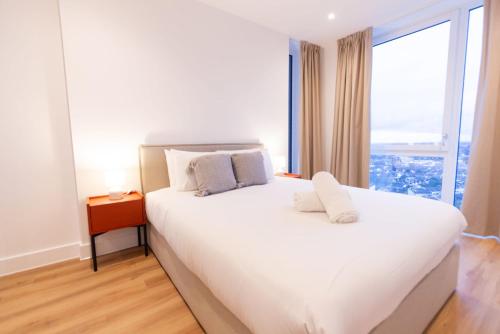 a bedroom with a large white bed with a window at The Blossoms - Croydon in Croydon