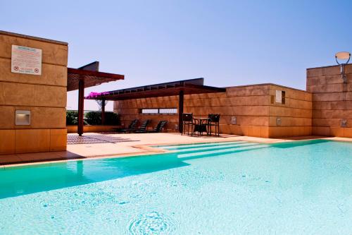 a swimming pool in front of a building at Raphael Suites in Johannesburg