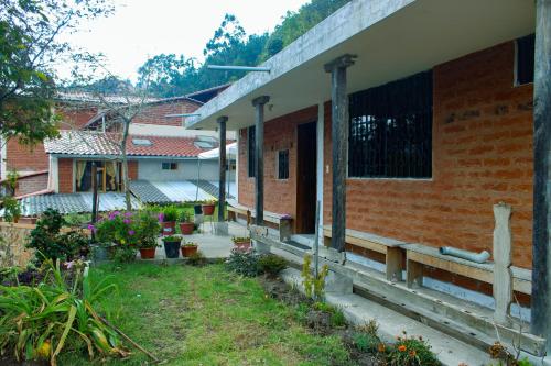 a brick building with a bench in a yard at Hostal Cloud Forest in Chugchilán