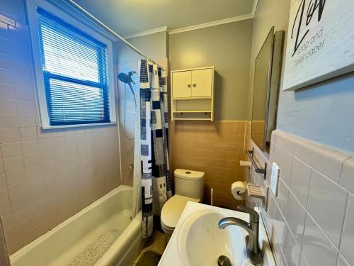a bathroom with a sink and a toilet and a tub at Cozy 1 BR, walk to subway, Free WiFi & Parking in Belleville