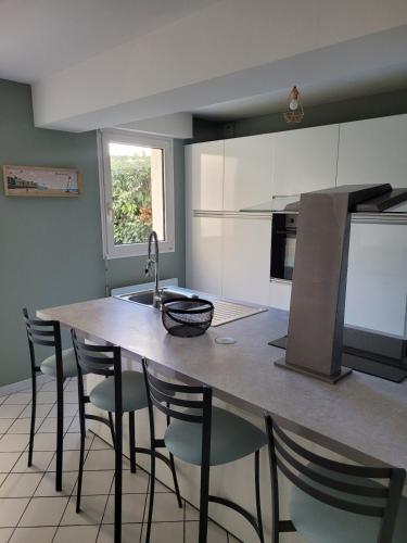 - une cuisine avec une table, des chaises et un évier dans l'établissement T2 Proche plage aux phoques avec parking, à Berck-sur-Mer