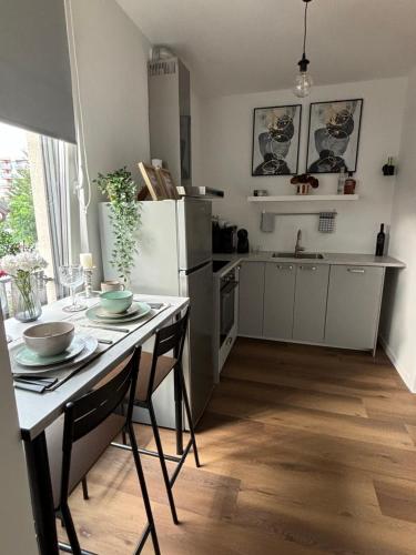 a kitchen with a table and a white refrigerator at ELLY Arena Zagreb Apartment in Zagreb