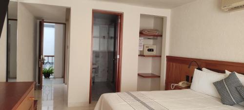 a bedroom with a bed and a door to a balcony at Hotel Marques Del Valle in Oaxaca City