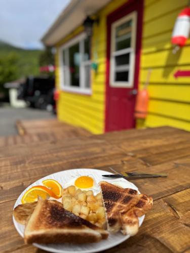 een bord eieren en toast op een tafel bij Knotty Pine Cottages, Suites & Motel Rooms in Ingonish Beach