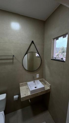 a bathroom with a sink and a mirror at Hotel Brasil in Ortigueira