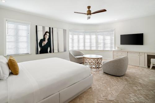 a white bedroom with a large bed and a tv at Cardozo Hotel in Miami Beach