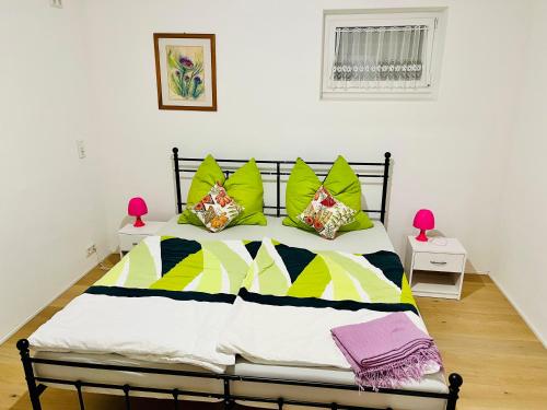 a bed with colorful pillows on it in a room at Ferienwohnung Sommerblüte in Schweich