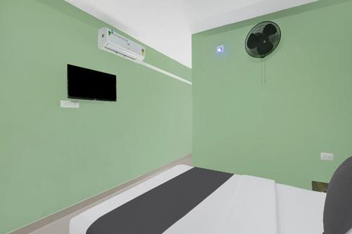 a hospital room with a bed and a tv at Super Hotel O Olive Residency in Calicut