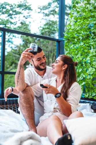 a man and woman sitting on a bed looking at a cell phone at Cabaña Montecielo San Rafael in San Rafael