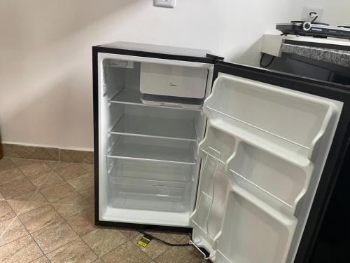 an empty refrigerator with its door open in a kitchen at Condomínio Residencial Vitória 3 in Sao Paulo