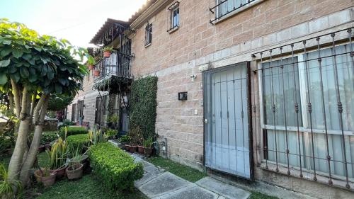 ein Backsteingebäude mit einer Tür und einigen Pflanzen in der Unterkunft Casa en Cuernavaca Casa Luz in Cuernavaca