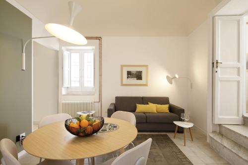 un soggiorno con un tavolo e un divano di L'arco di San Giuseppe a Siracusa