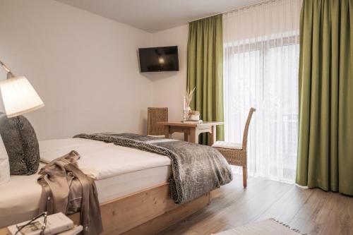 a hotel room with a bed and a window at Restaurant Gästehaus Wiesenheim in Uderns