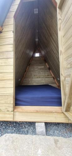 a small wooden bed in a wooden house at Ecox Hostel Cabanas 2 in Penha