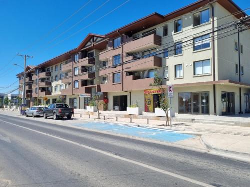 an apartment building on a city street with cars parked at Departamento Corporativo II Talca Las Rastras ' Valles del Country - RENTCOVAC - Factura Inmediata in Talca
