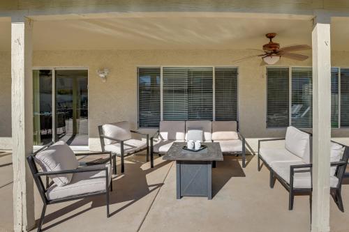 a patio with chairs and a table and a ceiling fan at Putting Green, Pool and Spa Home in Queen Creek! in Queen Creek