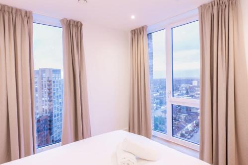 a bedroom with a large window with a view of a city at The Blossoms - Croydon in Croydon