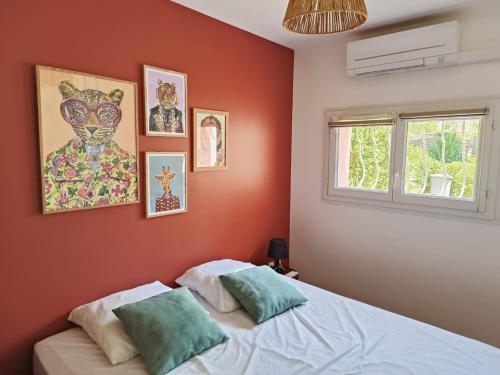 - une chambre avec des murs rouges et un lit avec deux oreillers dans l'établissement Super appartement 80m de la plage de plain pied avec 50m2 extérieur, à Saint-Raphaël