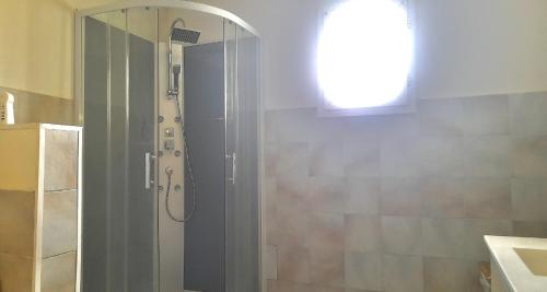 une salle de bain avec une douche avec une porte vitrée dans l'établissement 2ème chambre dans appartement 2 chambres proche mer, centre-ville et commerces, à Bastia