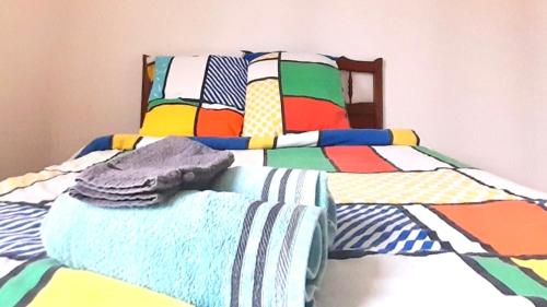 - un lit avec une couette colorée dans l'établissement 2ème chambre dans appartement 2 chambres proche mer, centre-ville et commerces, à Bastia