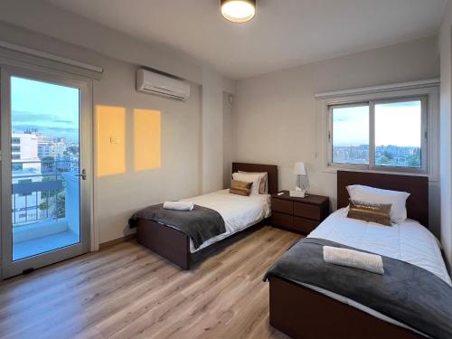 Un dormitorio con dos camas y una gran ventana. en River View Apartment in center Nicosia, en Nicosia