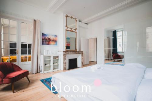 une chambre blanche avec un lit et une cheminée dans l'établissement Le grand luxueux des Carmes appartement neuf de grand standing, à Nancy