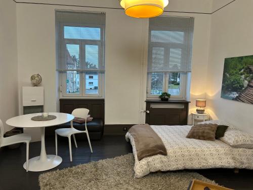 una camera da letto con un letto, un tavolo e finestre di Bannacker 1 a Wissembourg