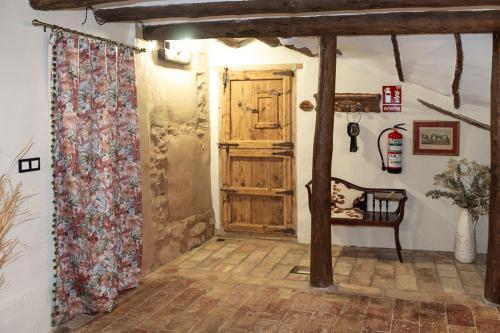 a hallway with a wooden door and a chair in a room at Casa rural Bisimbre in Bisimbre