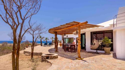 ein Haus mit einer hölzernen Pergola auf einer Terrasse in der Unterkunft Entire Villa Private Beach Front Oasis at Punta Lobos - Casa Punta Lobos in Todos Santos