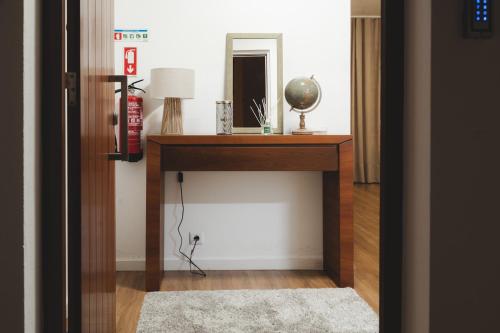 a room with a table with a mirror and a lamp at Casa da Relva in Ponta Delgada