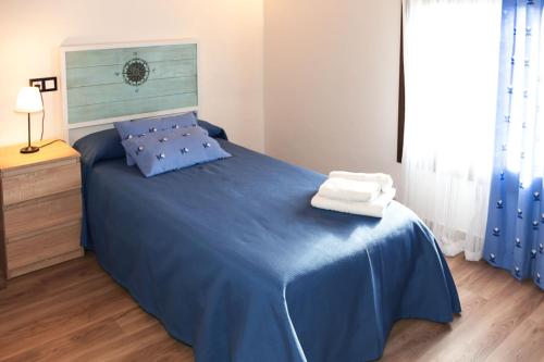 a bedroom with a blue bed with a blue blanket at Casa rural Bisimbre in Bisimbre