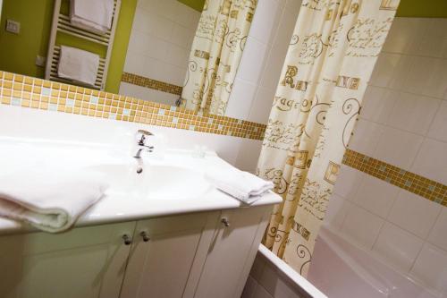 baño con lavabo y cortina de ducha en Residhotel Lyon Lamartine, en Tassin-la-Demi-Lune