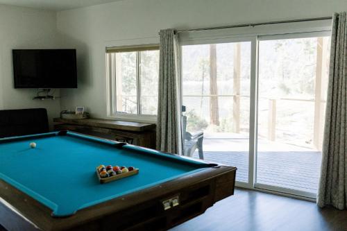 a living room with a pool table and a sliding glass door at Werner Lake Front in Bass Lake