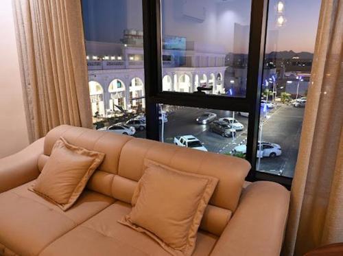 a couch in a room with a large window at Sunset Hotel for Hotel Services in Najran