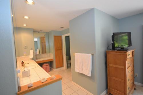 a bathroom with a sink and a tv on a cabinet at King- Lake Area in Bass Lake