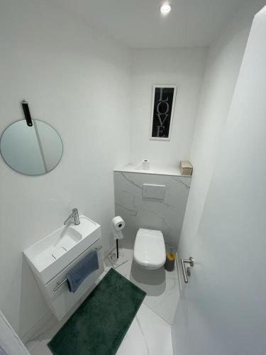 une salle de bain blanche avec un lavabo et des toilettes dans l'établissement Modern Chic Seaview Appartement, à Cannes
