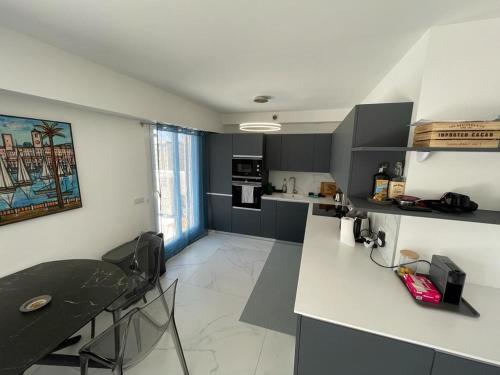 - une cuisine avec un comptoir et une table dans une pièce dans l'établissement Modern Chic Seaview Appartement, à Cannes