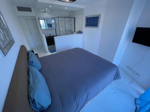 une chambre avec un lit avec des oreillers bleus dans l'établissement Modern Chic Seaview Appartement, à Cannes