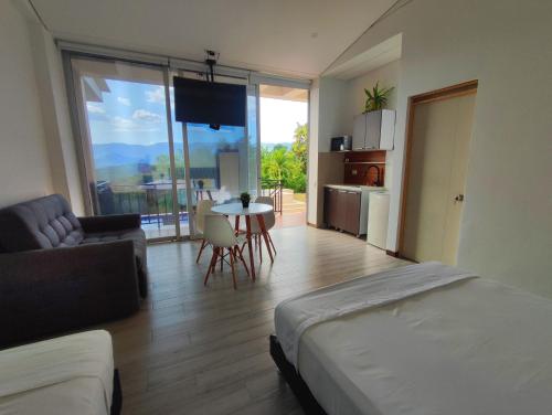 a bedroom with a bed and a living room with a table at Mountain View Anapoima in Anapoima