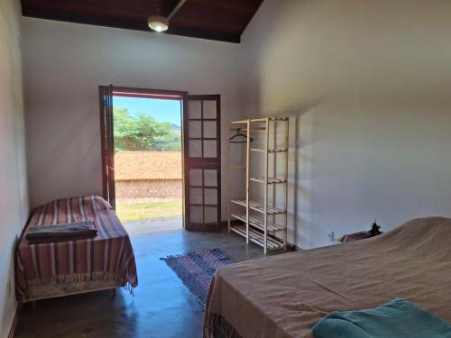 a room with a bed and a room with a door at Caminho da Toca in Passa Quatro