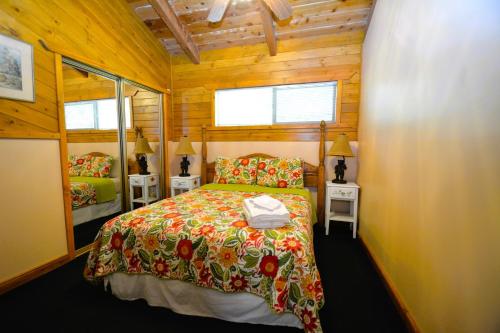 a bedroom with a bed in a wooden cabin at Johnson Lake Frontreduced Nightly Rates in Bass Lake