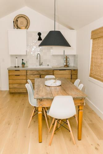 a kitchen with a wooden table and white chairs at Casita- Lake Area in Bass Lake
