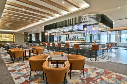ein Restaurant mit Tischen und Stühlen und eine Bar in der Unterkunft Sheraton Laval Hotel in Laval