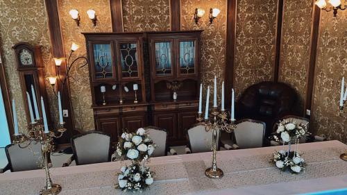 a dining room with a table and chairs and a wall at Hotel Oaza in Kikinda